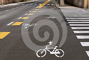 Two way bike lane along the urban street with painted signs, directiona arrows and crosswalks