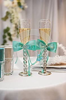 Two wedding glasses decorated with blue bows