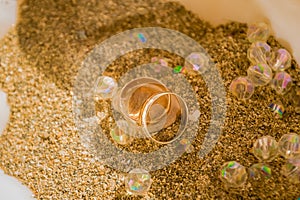 Two wedding ring on sand in a shell