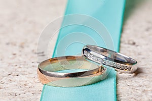 Two wedding ring of white and yellow gold on green strap