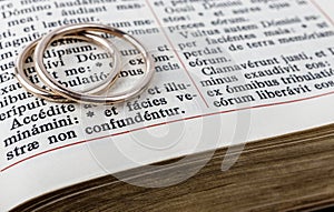 Two wedding rings on a bible page