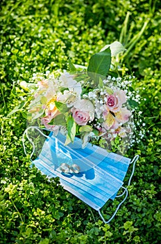 Two wedding rings lie on medical masks on the background of a wedding bouquet. Quarantine Wedding