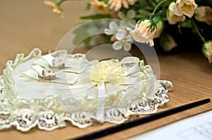 Two wedding rings lie on a pillow for ceremonies