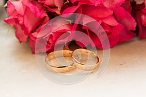 Two wedding rings, red roses