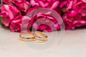 Two wedding rings, red roses