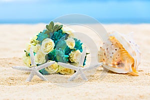 Two wedding rings with two starfish, wedding bouquet and a large
