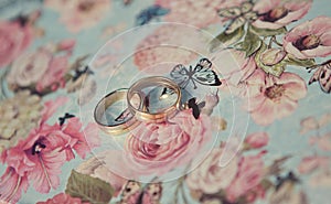 Two wedding rings of white gold on a blue butterflies metal box