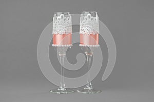 Two wedding wine glasses decorated with lace and pearls.