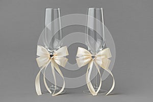 Two wedding wine glasses decorated with ribbons of cream color