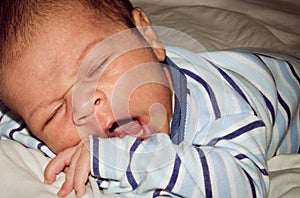 Two weeks old newborn baby boy sleeping on white sheet
