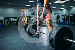 Two weightlifters doing exercise with barbells