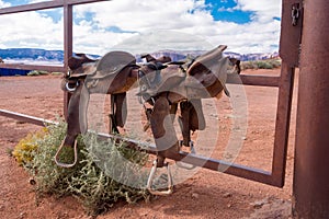 Two Western Saddles Sitting on a Metal Gate.