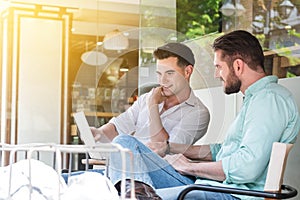 Two Westerner Business men working with laptop and smartphone to