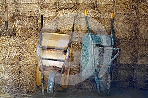 Two wheelbarrows on the hay background