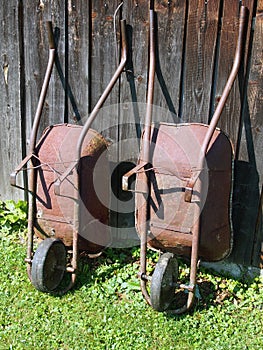 Two wheelbarrows at wooden barn