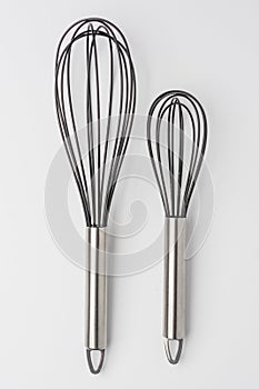 Two Whisks on White Background Top View
