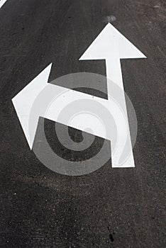 Two white arrows on asphalt