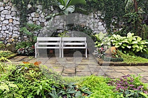 Two white benches inside garden