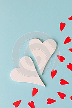 Two white big hearts and small red hearts on the blue background