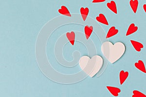 Two white big hearts and small red hearts on the blue background