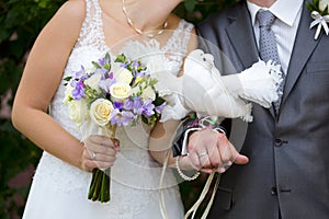 Two white birds - pigeons - on hands of bride and groom