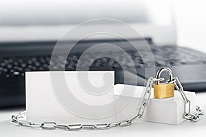 Two white business cards on PC background, lock, chain. Protection of business and finance. Protection of personal information and photo