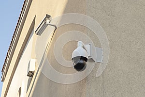 two white CCTV cameras on the wall of the building.