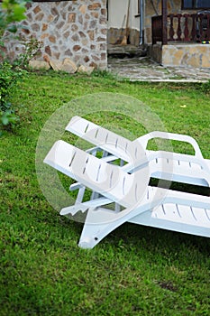Two white chairs on a lawn