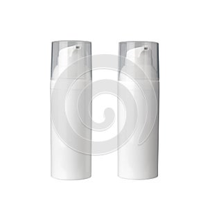 Two white cosmetic cream bottles with dispenser on white background isolated closeup, face cream bottle with transparent caps set