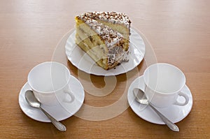 Two white cups of tea and cake