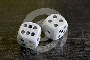 Two white dice gamble on a black background