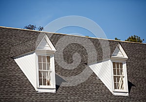 Two White Dormers on Grey Shingle Roof photo