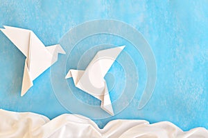 Two white dove paper cutout in blue background template with copy space.