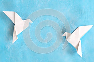 Two white dove paper cutout in blue background template with copy space.
