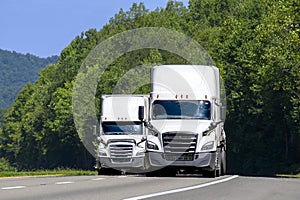 Two White Eighteen-Wheelers On The Interstate With Copy Space