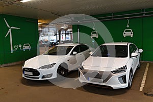 Two Electric cars charging in parking house photo