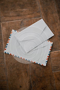 Two white envelopes on a wooden table