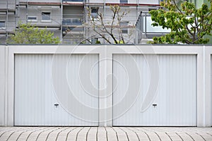 Two white garage doors in a European city. Garages for two cars
