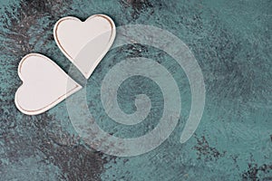 Two white hearts on a blue textured shabby background, empty space for text