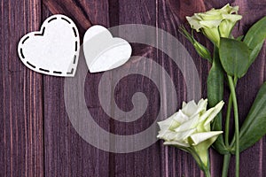 Two white hearts of felt and flowers on a brown wooden background. Valentine Day. Greeting Card. Wedding.