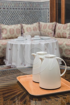 Two white jugs on the wooden table in Moroccan house