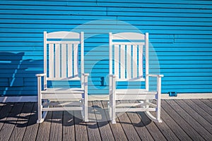 Two White  outdoor wooden chairs Against Blue wall