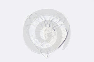 Two white paper lace hearts on light background