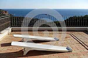 Two white plastic sunloungers photo