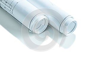 Two white rolled up blueprints isolated very close  up