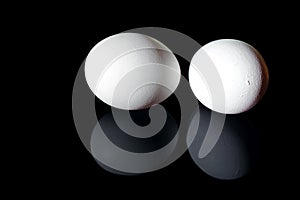 Two white shell eggs isolated on black background