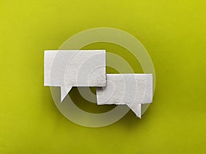 Two white speech bubbles on a lime green background