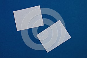 Two white sticky notes on blue wall