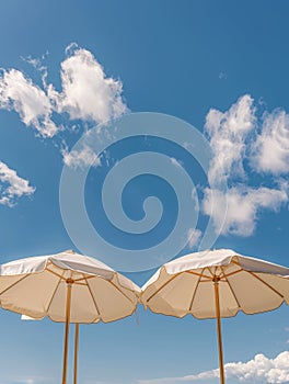 Two White Umbrellas on Sandy Beach