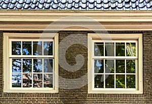 Two white vintage sash windows in brown brick wall